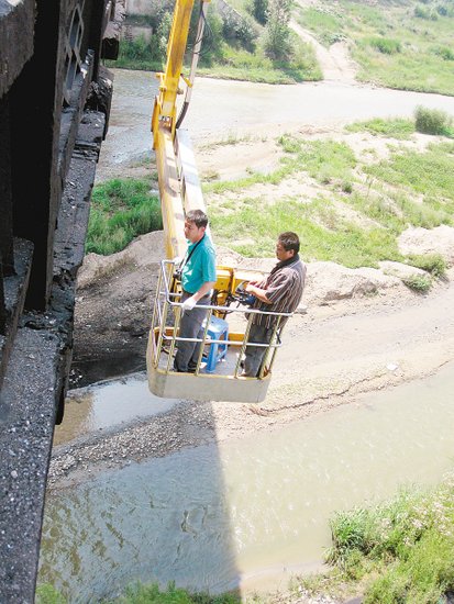 工作人员正在检查桥体受损情况。